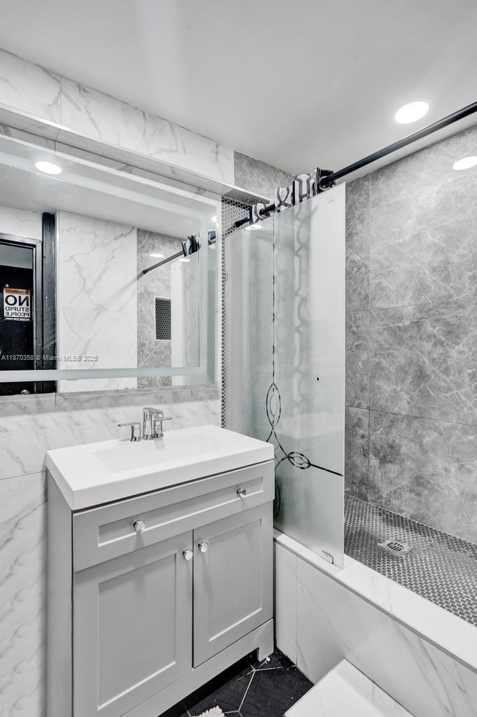 900 Crystal Lake Drive, Unit 2B Deerfield Beach, FL 33073 - Photo 21 of 41 a bathroom with a sink vanity granite tub shower and a mirror