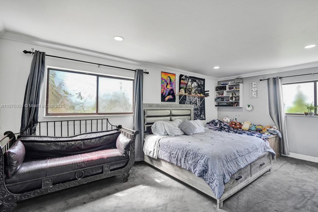 900 Crystal Lake Drive, Unit 2B Deerfield Beach, FL 33073 - Photo 22 of 41 a bedroom with a bed couch and a large window