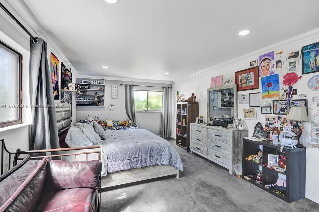 900 Crystal Lake Drive, Unit 2B Deerfield Beach, FL 33073 - Photo 24 of 41 a bedroom with a bed furniture and flat screen tv