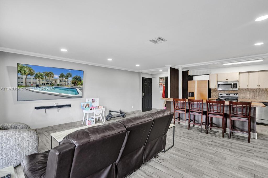 900 Crystal Lake Drive, Unit 2B Deerfield Beach, FL 33073 - Photo 4 of 41 a view of a dining room with furniture and wooden floor