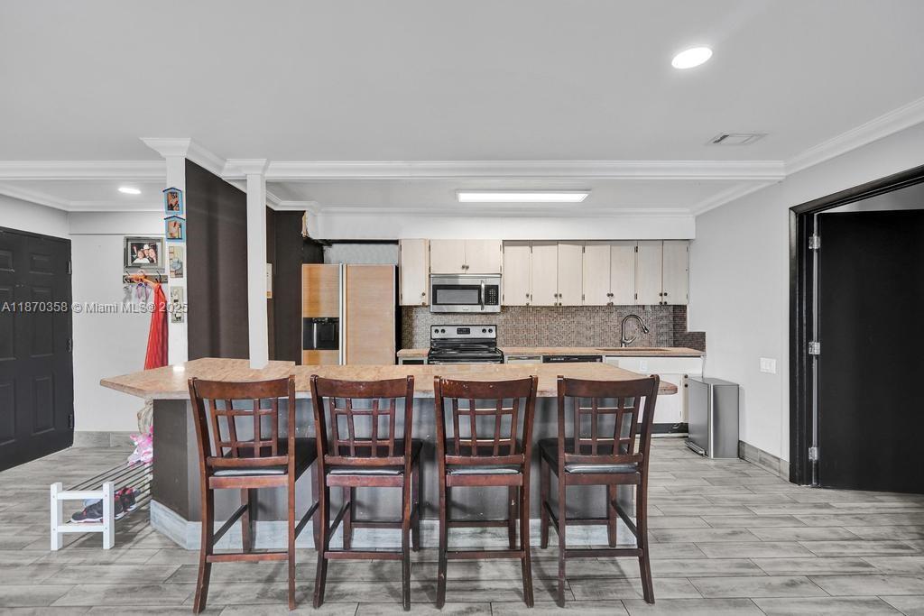 900 Crystal Lake Drive, Unit 2B Deerfield Beach, FL 33073 - Photo 5 of 41 a dining area with stainless steel appliances a table and chairs