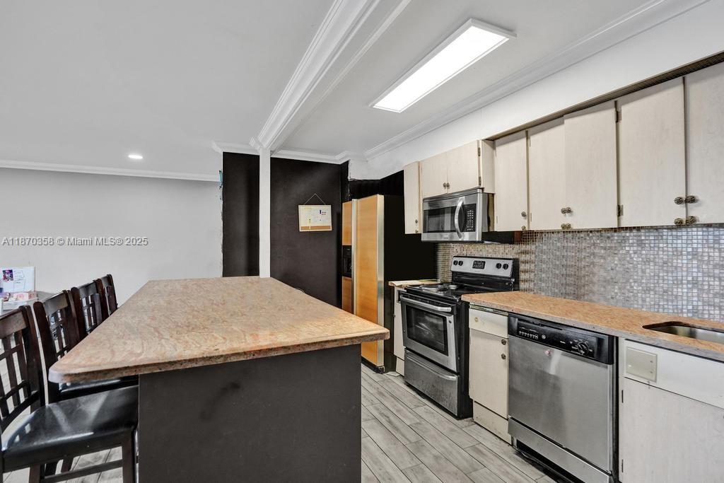 900 Crystal Lake Drive, Unit 2B Deerfield Beach, FL 33073 - Photo 7 of 41 a kitchen with stainless steel appliances granite countertop a stove refrigerator sink and microwave