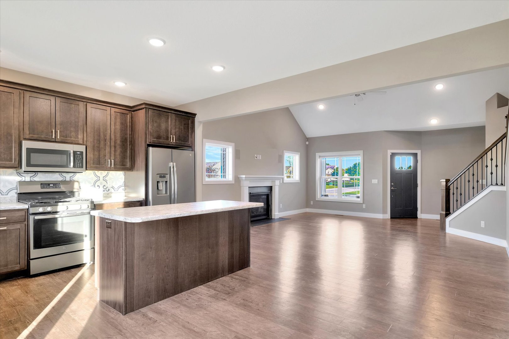 3402 Boulder Ridge Drive Champaign, IL 61822 - Photo 11 of 42 a kitchen with stainless steel appliances granite countertop a stove top oven a sink dishwasher a refrigerator and a dining table with wooden floor
