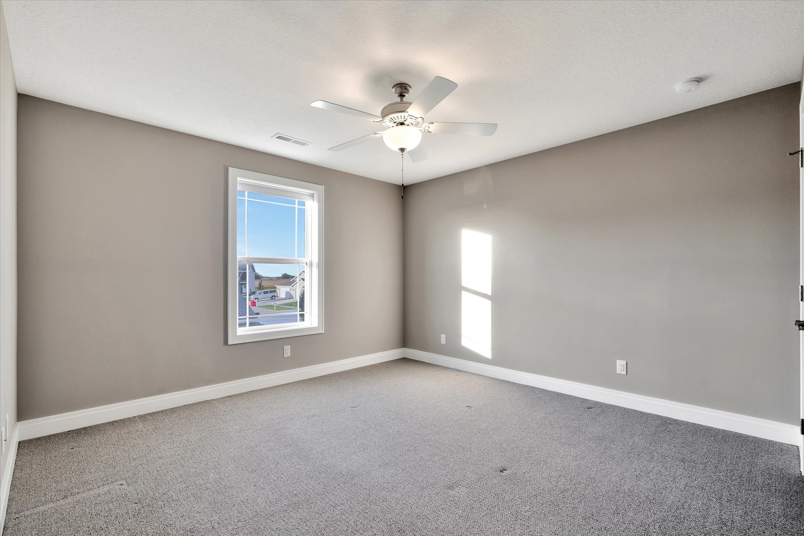 3402 Boulder Ridge Drive Champaign, IL 61822 - Photo 28 of 42 an empty room with windows and ceiling fan