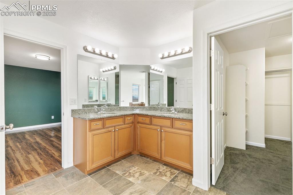 7678 Dutch Loop Colorado Springs, CO 80925 - Photo 16 of 29 a bathroom with a granite countertop sink and a mirror