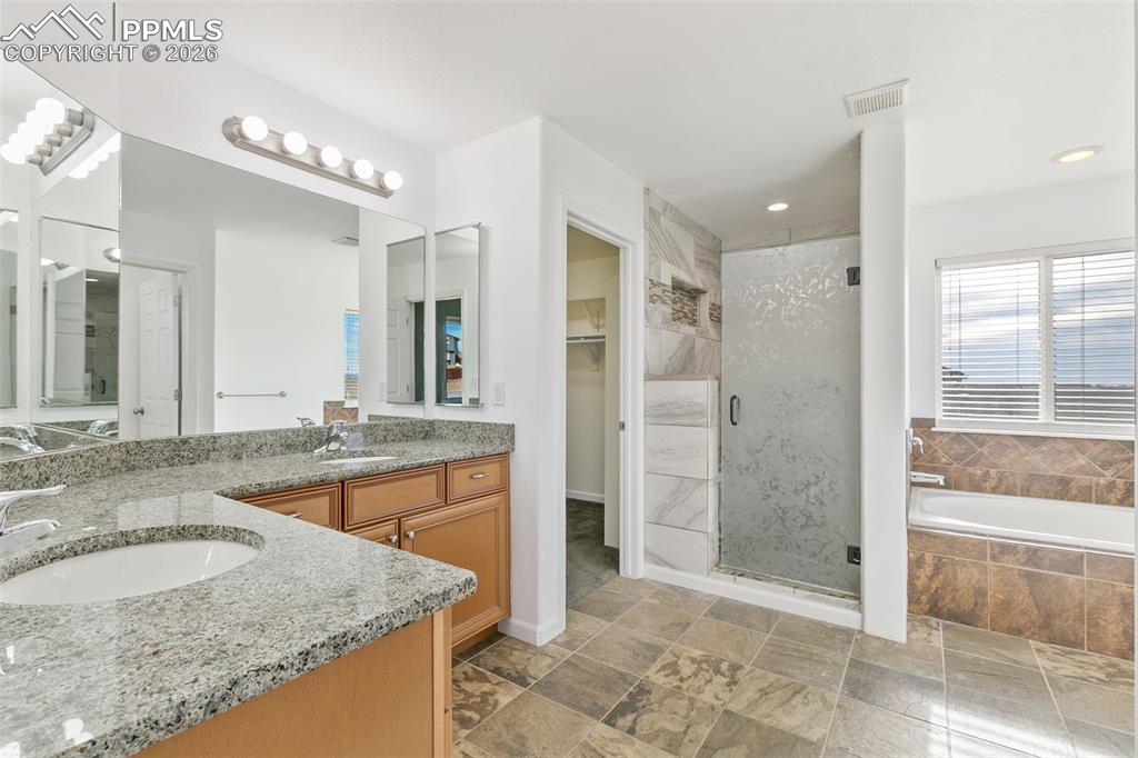 7678 Dutch Loop Colorado Springs, CO 80925 - Photo 17 of 29 a bathroom with a granite countertop sink and a mirror