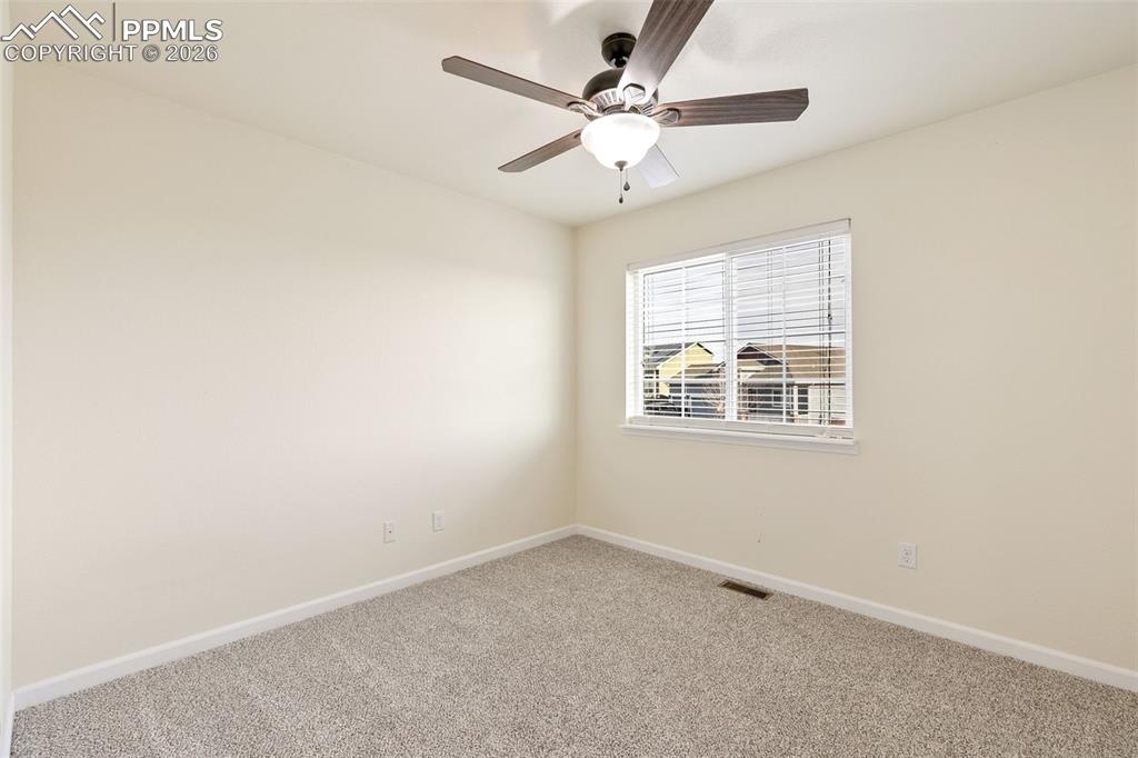 7678 Dutch Loop Colorado Springs, CO 80925 - Photo 18 of 29 an empty room with a window and a fan