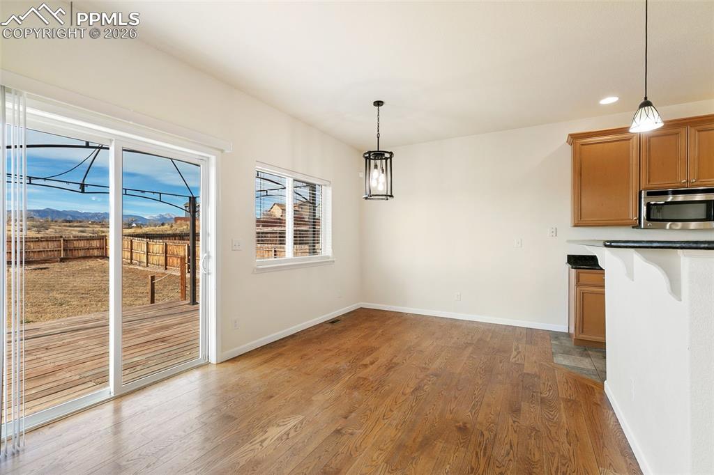 7678 Dutch Loop Colorado Springs, CO 80925 - Photo 7 of 29 a view of a kitchen with wooden floor fridge and a sink