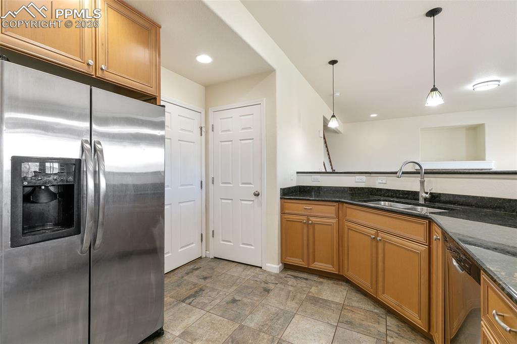 7678 Dutch Loop Colorado Springs, CO 80925 - Photo 10 of 29 a kitchen with stainless steel appliances granite countertop a refrigerator and a sink