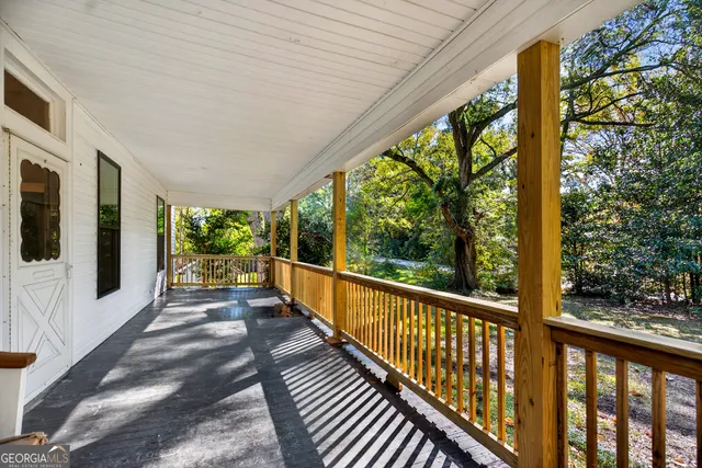 a view of a porch with wooden floor in front of house