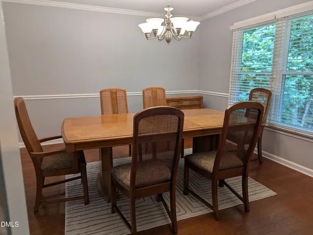 a view of a dining room with furniture a chandelier and wooden floor