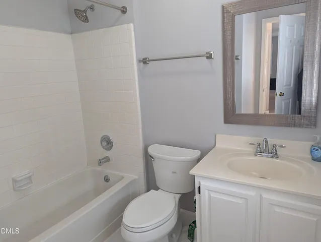 a bathroom with a toilet a sink a mirror and a bathtub