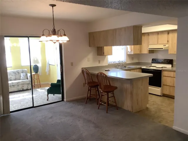 a kitchen with kitchen island a counter space a sink a stove and a refrigerator