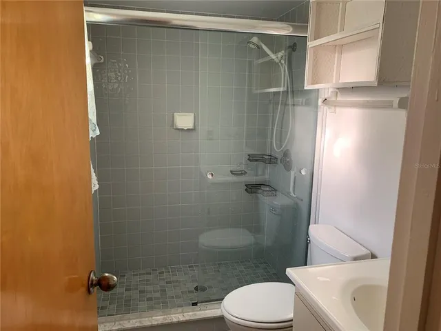 a bathroom with a shower a toilet and a sink