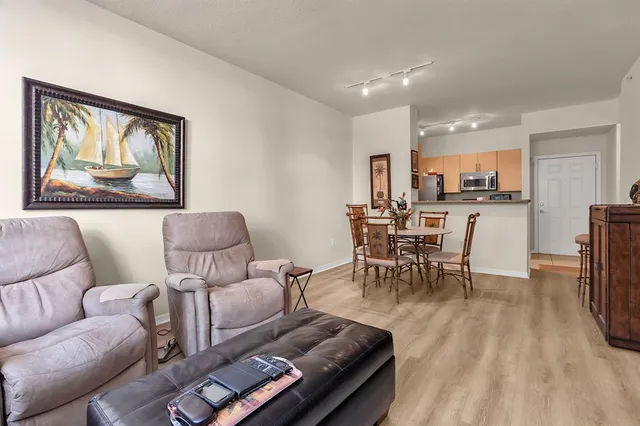 a living room with furniture and a dining table with kitchen view