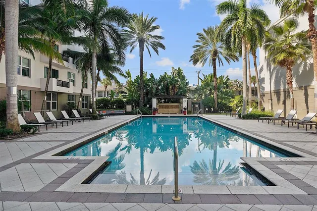 a view of swimming pool with palm trees