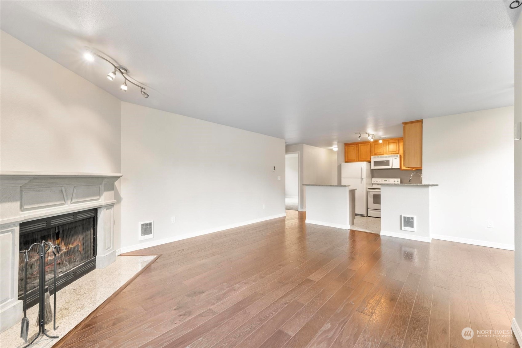 20328 Bothell Everett Highway, Unit B101 Bothell, WA 98012 - Photo 7 of 25 an empty room with wooden floor fireplace and windows