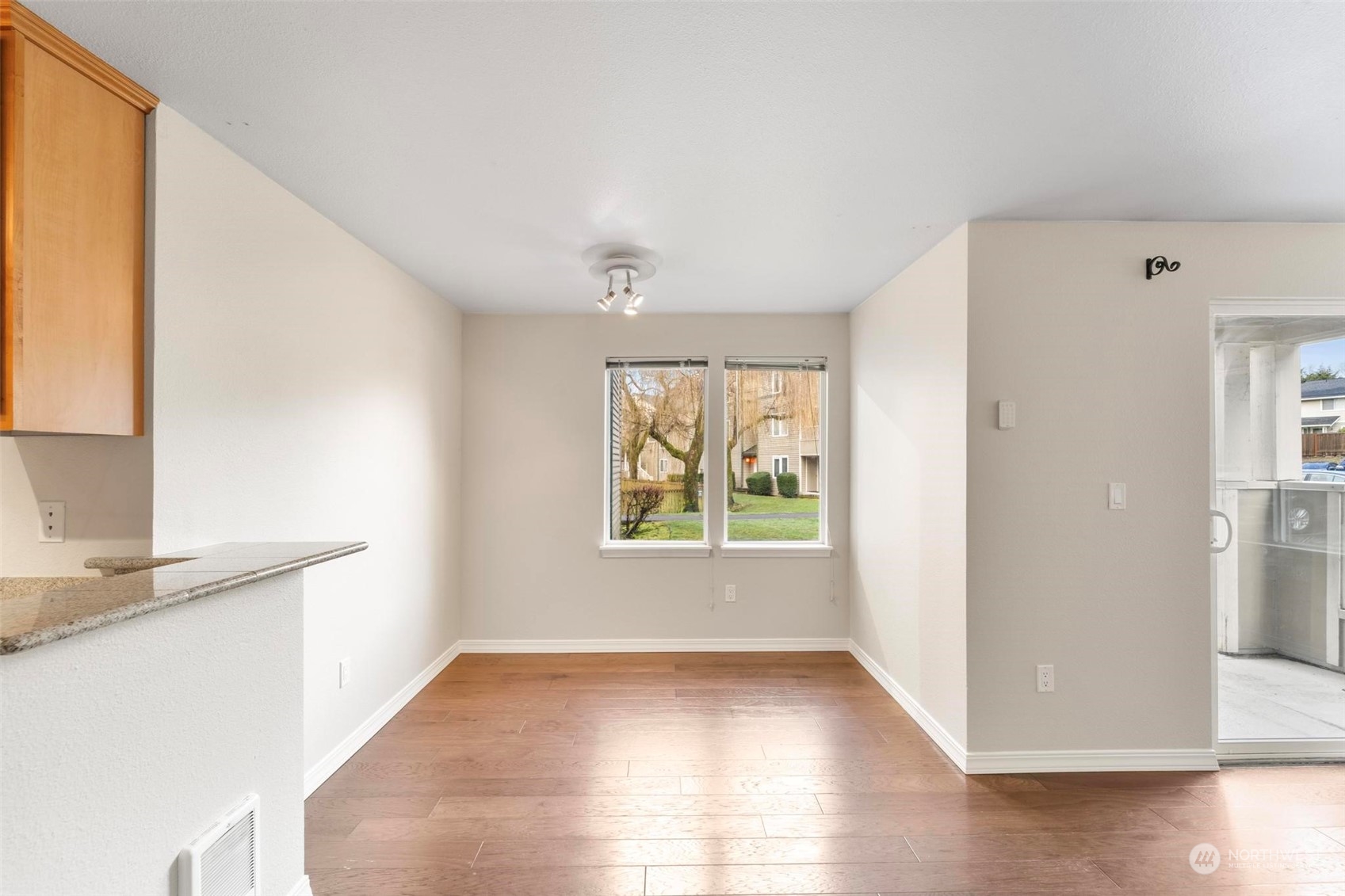 20328 Bothell Everett Highway, Unit B101 Bothell, WA 98012 - Photo 9 of 25 a view of an empty room with wooden floor and a window