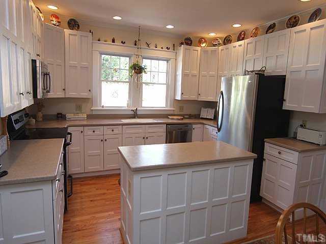 103 Georgetown Road Raleigh, NC 27608 - Photo 4 of 12 a kitchen with kitchen island granite countertop a stove a sink a refrigerator and cabinets
