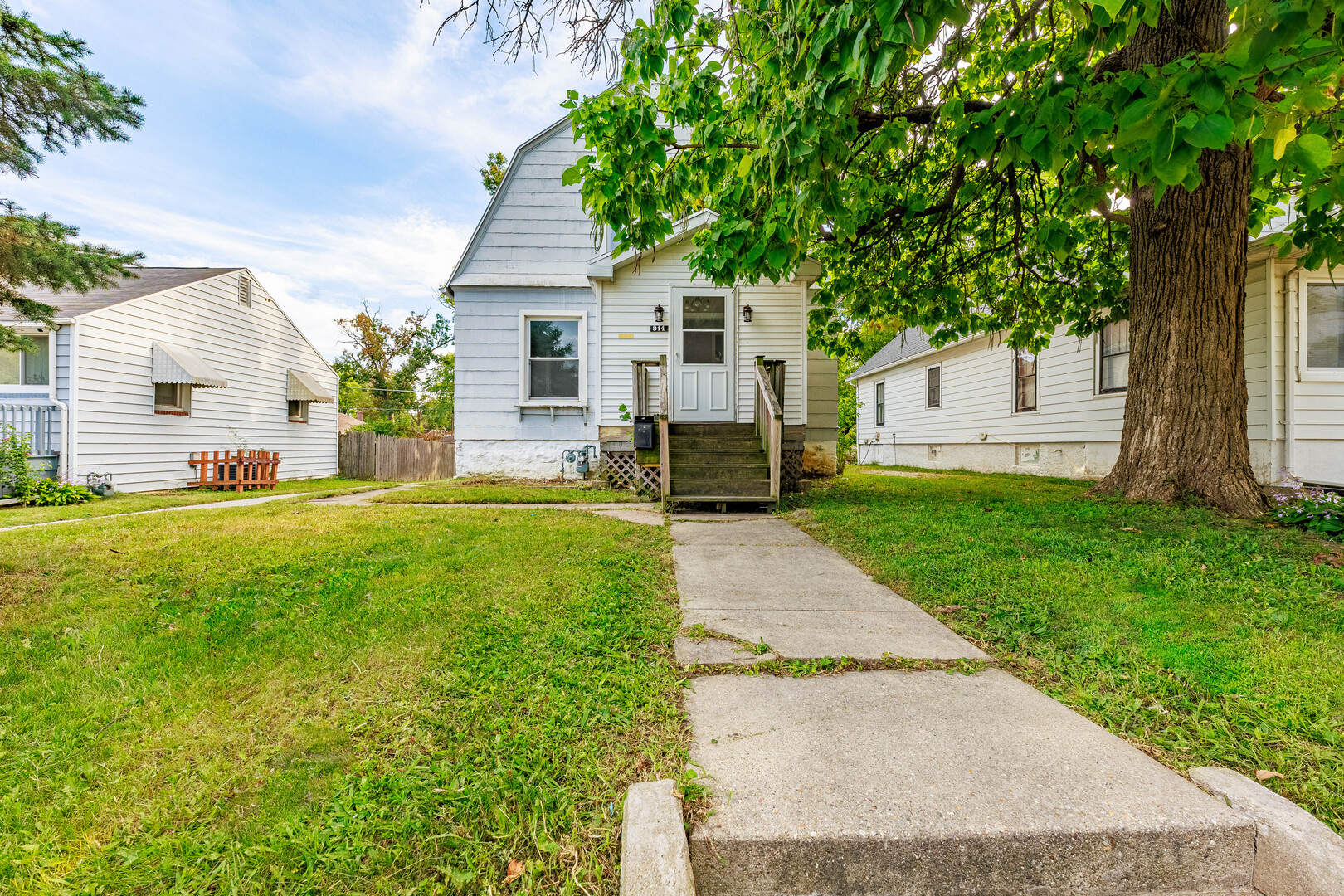a front view of a house with a yard and trees