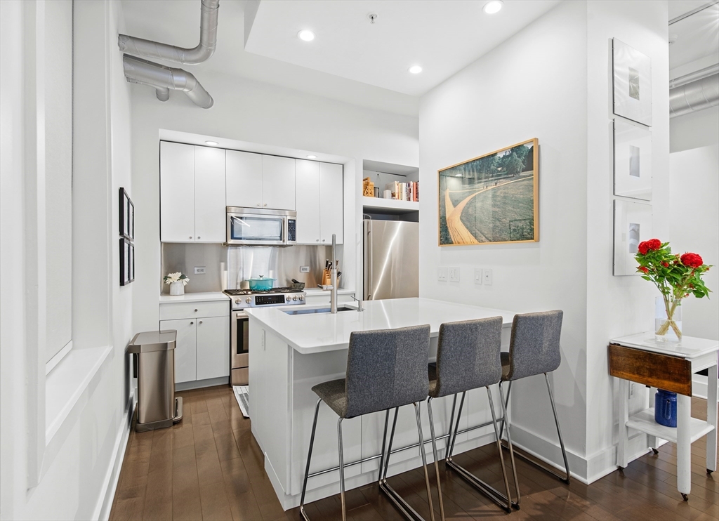 43-45 Winter Street, Unit 4 Boston, MA 02108 - Photo 13 of 24 a kitchen with a dining table chairs refrigerator and cabinets