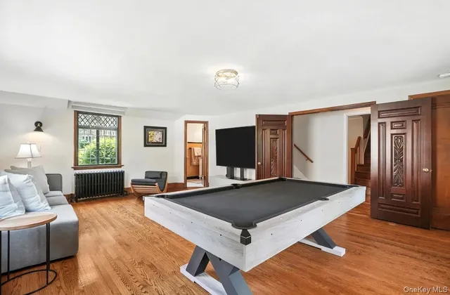 a living room with furniture pool table and a flat screen tv