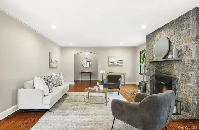 a living room with fireplace furniture and wooden floor