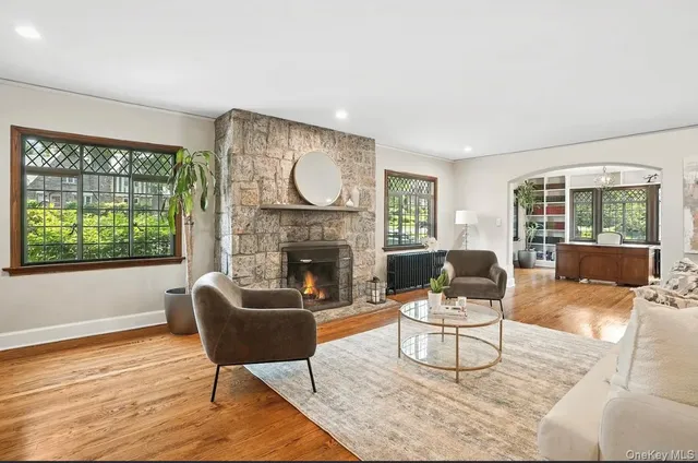 a living room with furniture a fireplace and a large window