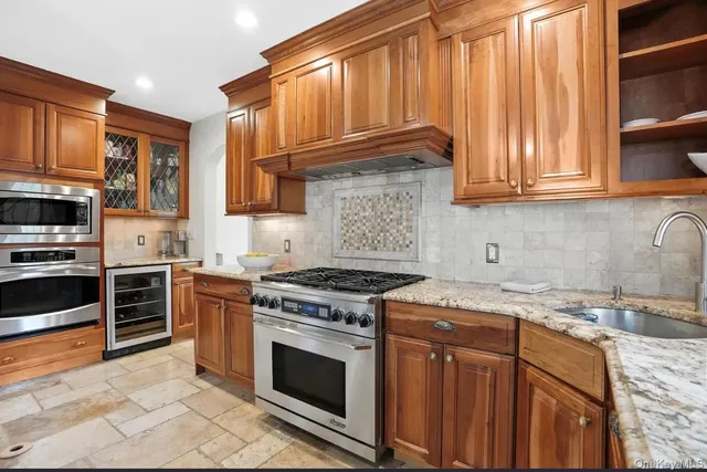 a kitchen with granite countertop a stove sink and cabinets