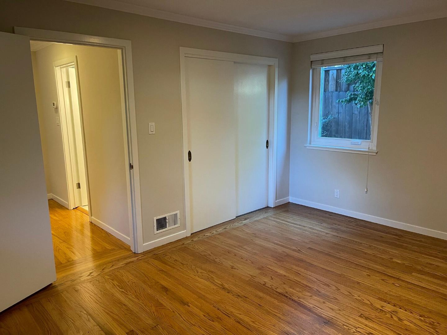 111 Elm Street, Unit 4 San Mateo, CA 94401 - Photo 7 of 9 a view of an empty room with wooden floor and a window