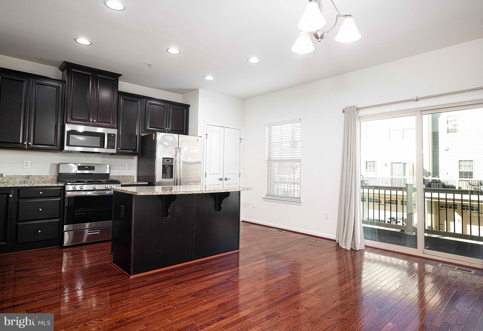 1032 Ramble Run Road Baltimore, MD 21220 - Photo 10 of 46 a kitchen with stainless steel appliances granite countertop a refrigerator a stove top oven a sink and dishwasher with wooden floor