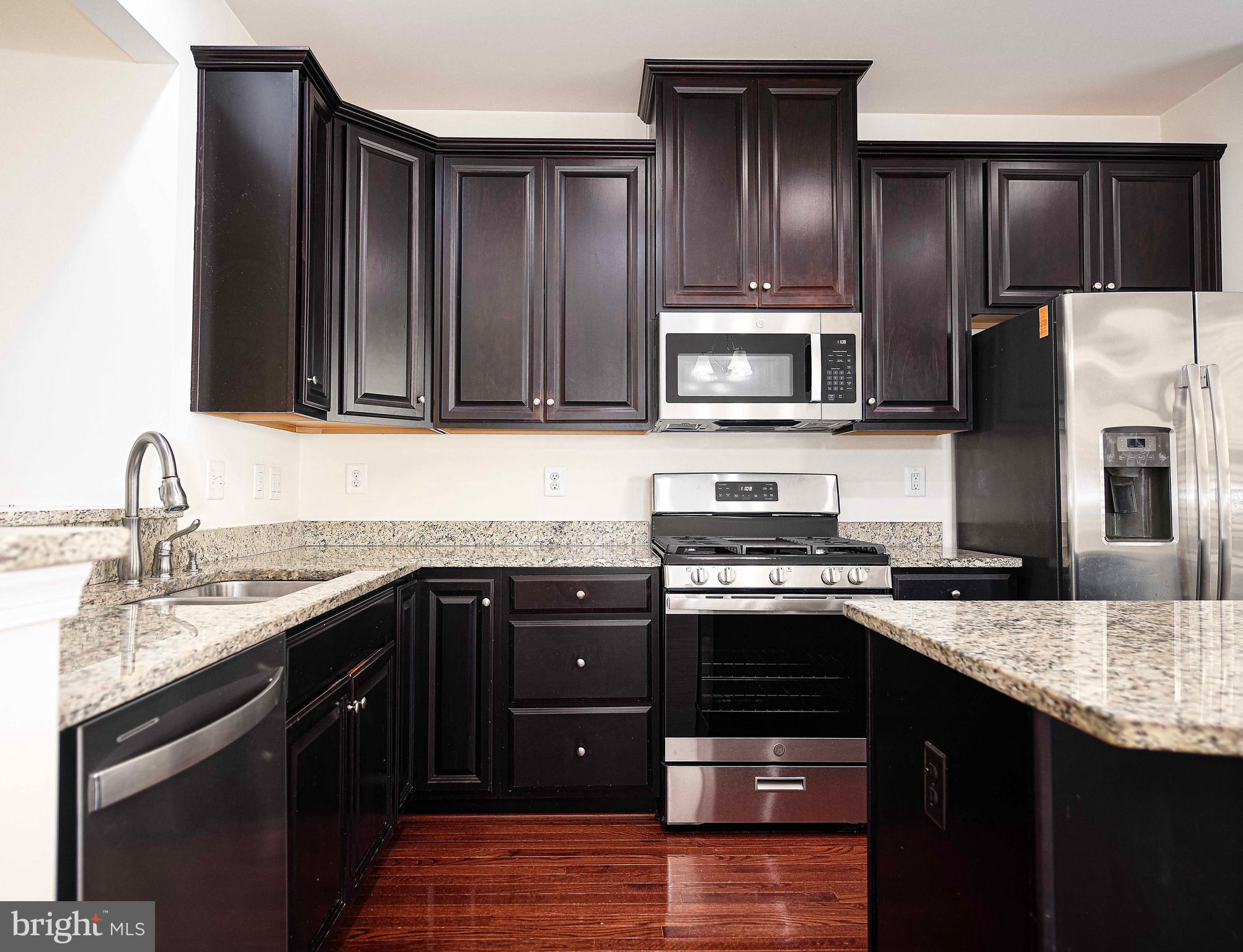 1032 Ramble Run Road Baltimore, MD 21220 - Photo 11 of 46 a kitchen with granite countertop stainless steel appliances and wooden cabinets