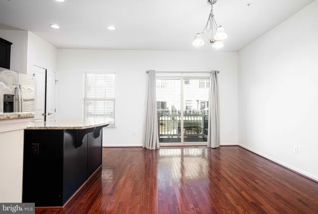 a kitchen with kitchen island granite countertop wooden floors stainless steel appliances and cabinets