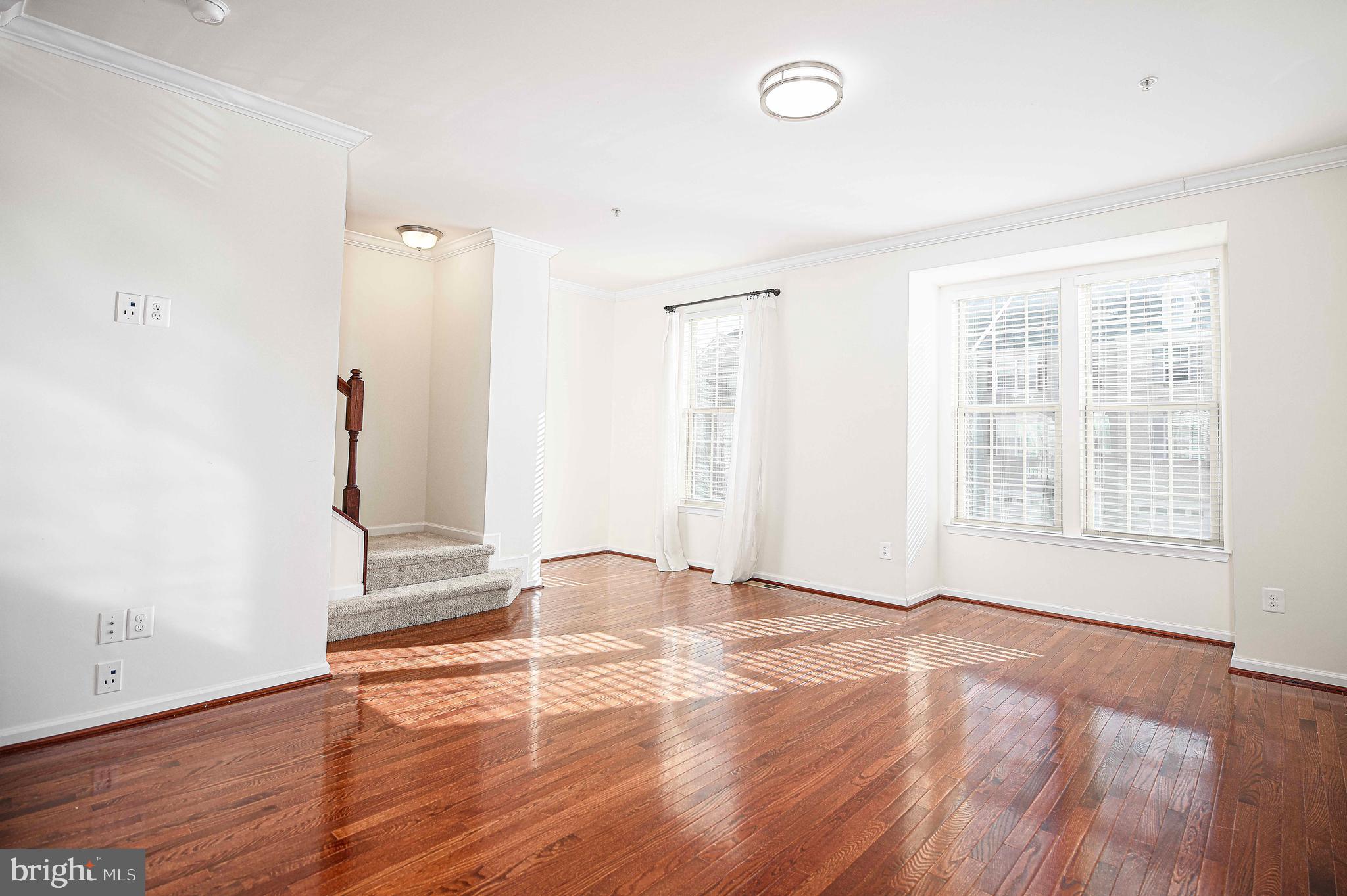 1032 Ramble Run Road Baltimore, MD 21220 - Photo 17 of 46 an empty room with wooden floor and windows