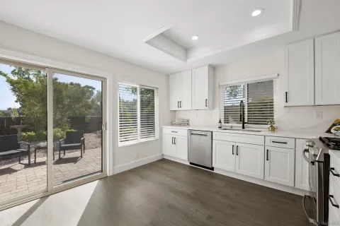 a kitchen that has a lot of cabinets in it and wooden floors
