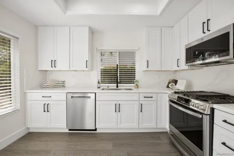 a kitchen with granite countertop white cabinets and appliances