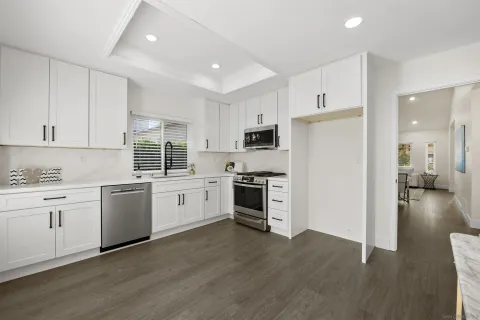 a kitchen with white cabinets and white appliances