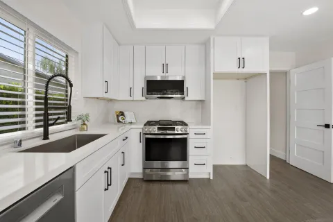 a kitchen with stainless steel appliances a stove a sink and a microwave