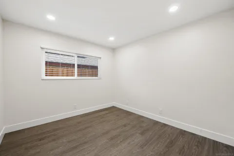 a view of a room with wooden floor and window