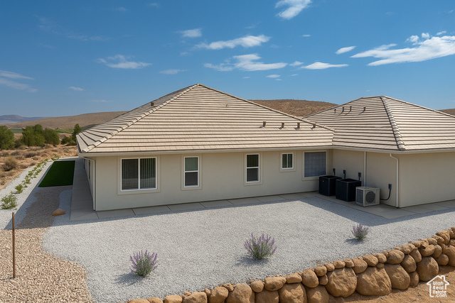 230 Boulder Way Leeds, UT 84746 - Photo 50 of 72 Rear view of house showing a tile roof and stucco siding with low maintenance landscaping. Concrete sidewalks surround the home.