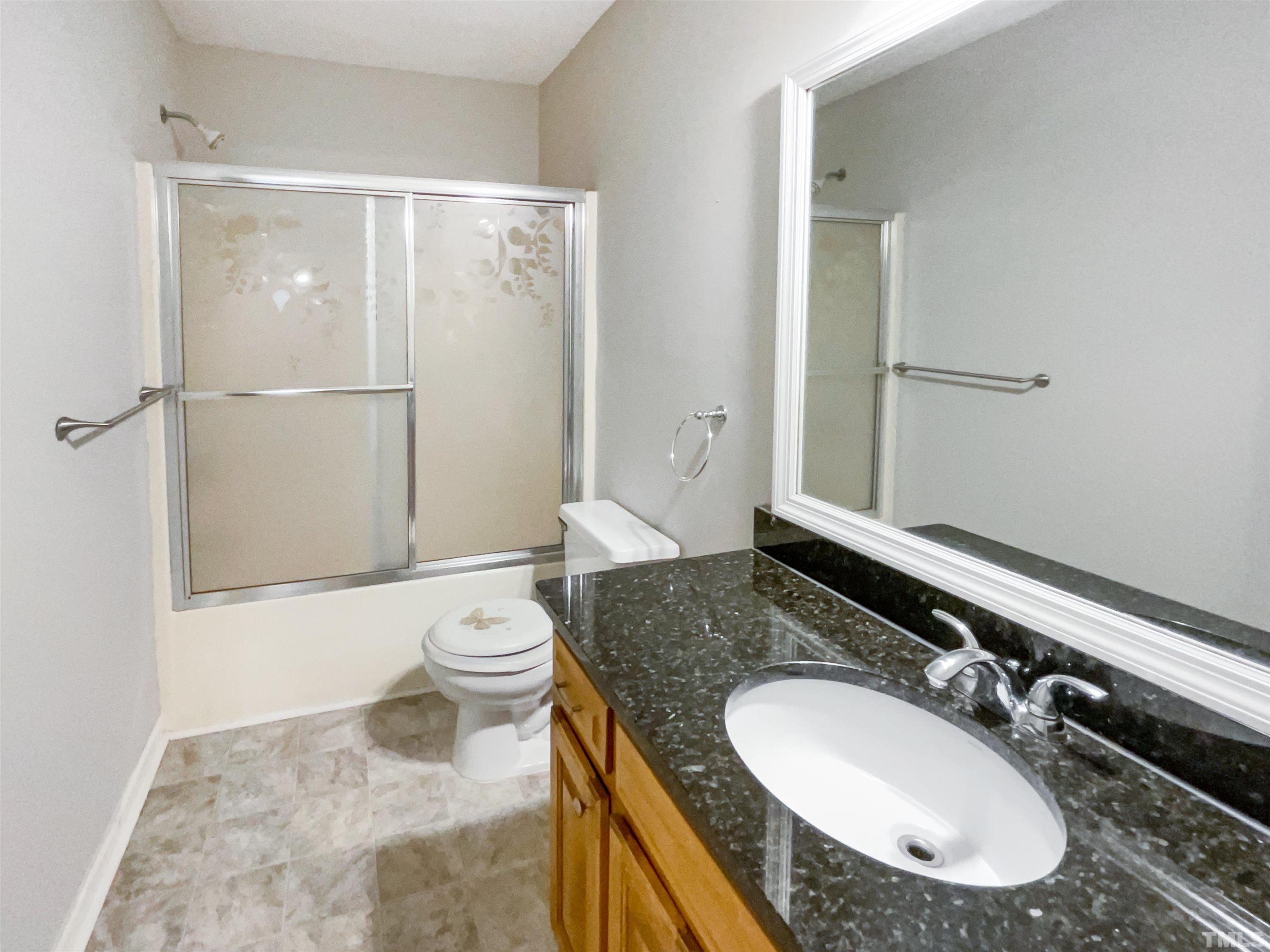 1459 Atkins Road Fuquay-Varina, NC 27526 - Photo 12 of 21 a bathroom with a granite countertop sink toilet and shower