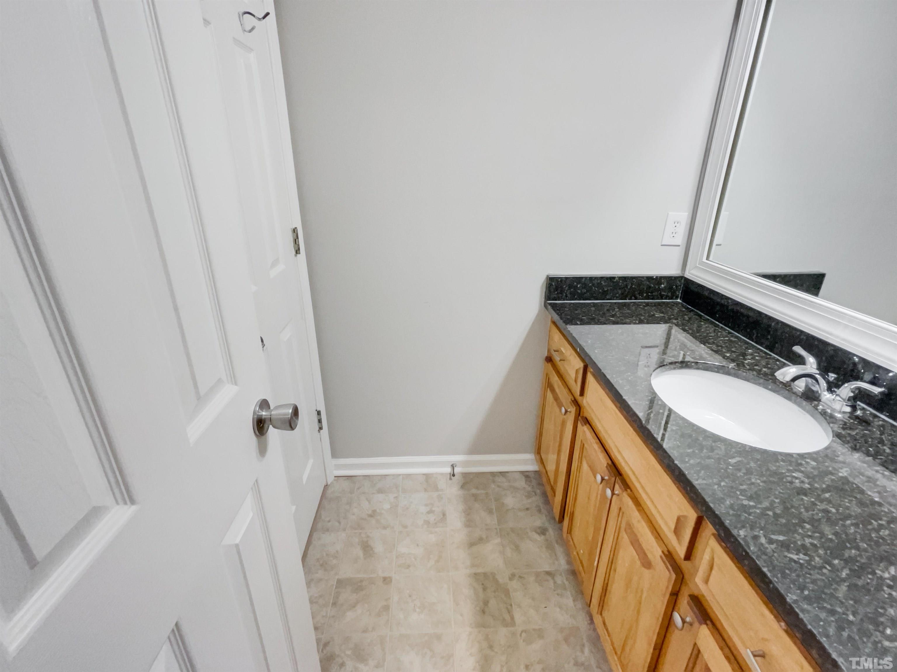 1459 Atkins Road Fuquay-Varina, NC 27526 - Photo 16 of 21 a bathroom with a sink and a mirror