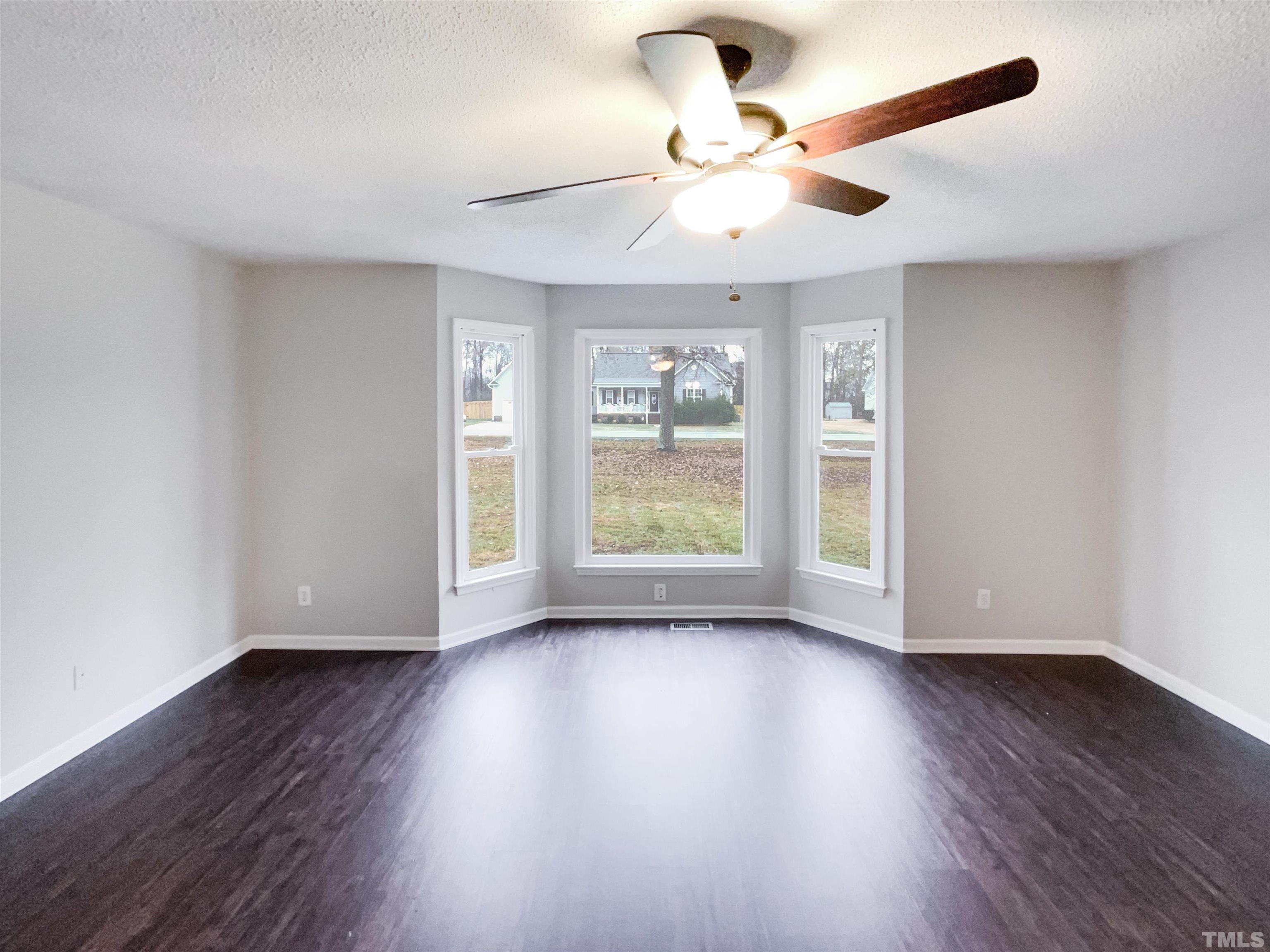 1459 Atkins Road Fuquay-Varina, NC 27526 - Photo 6 of 21 a view of an empty room with wooden floor and a window