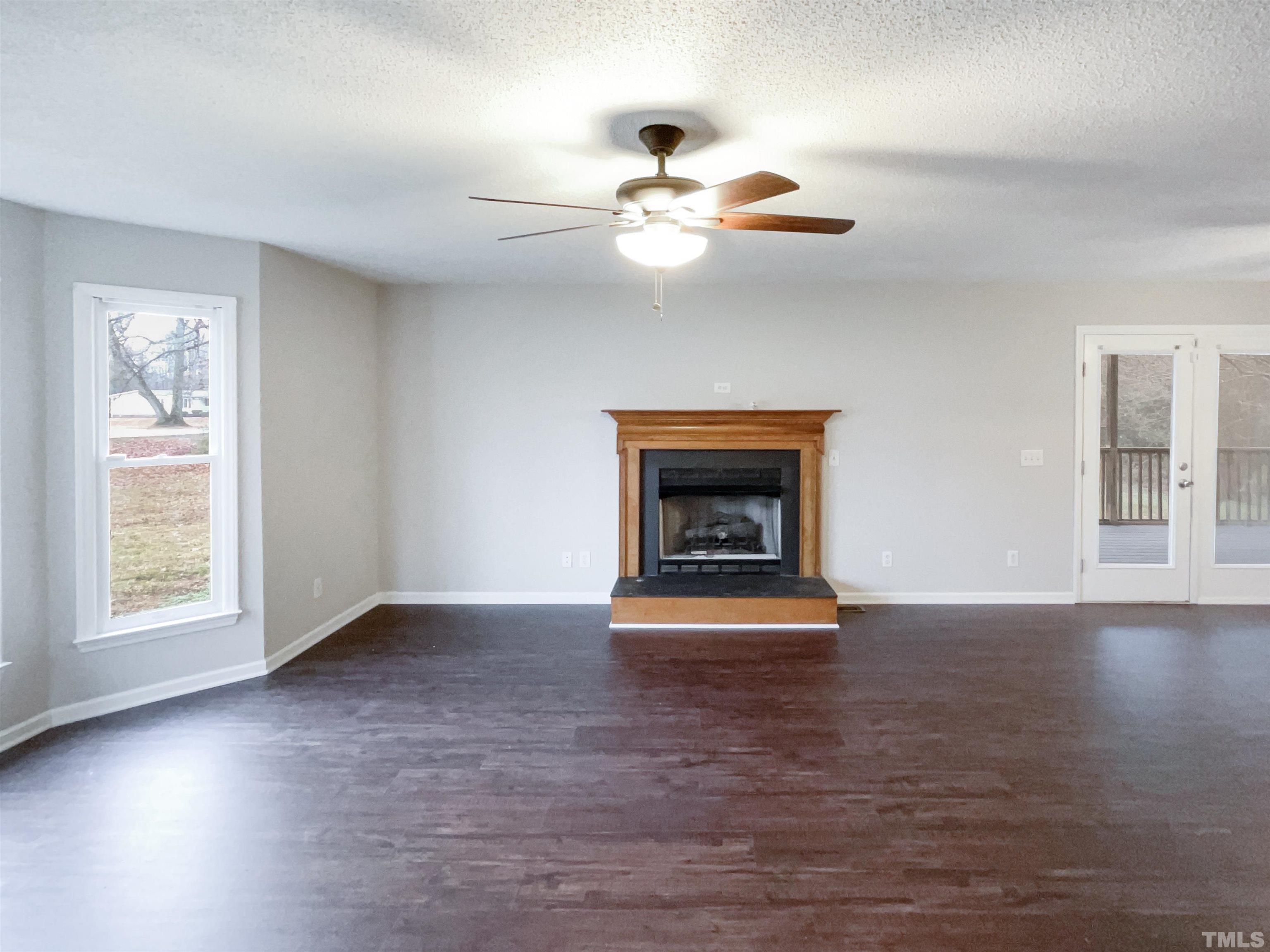 1459 Atkins Road Fuquay-Varina, NC 27526 - Photo 7 of 21 a view of an empty room with wooden floor fridge and a window