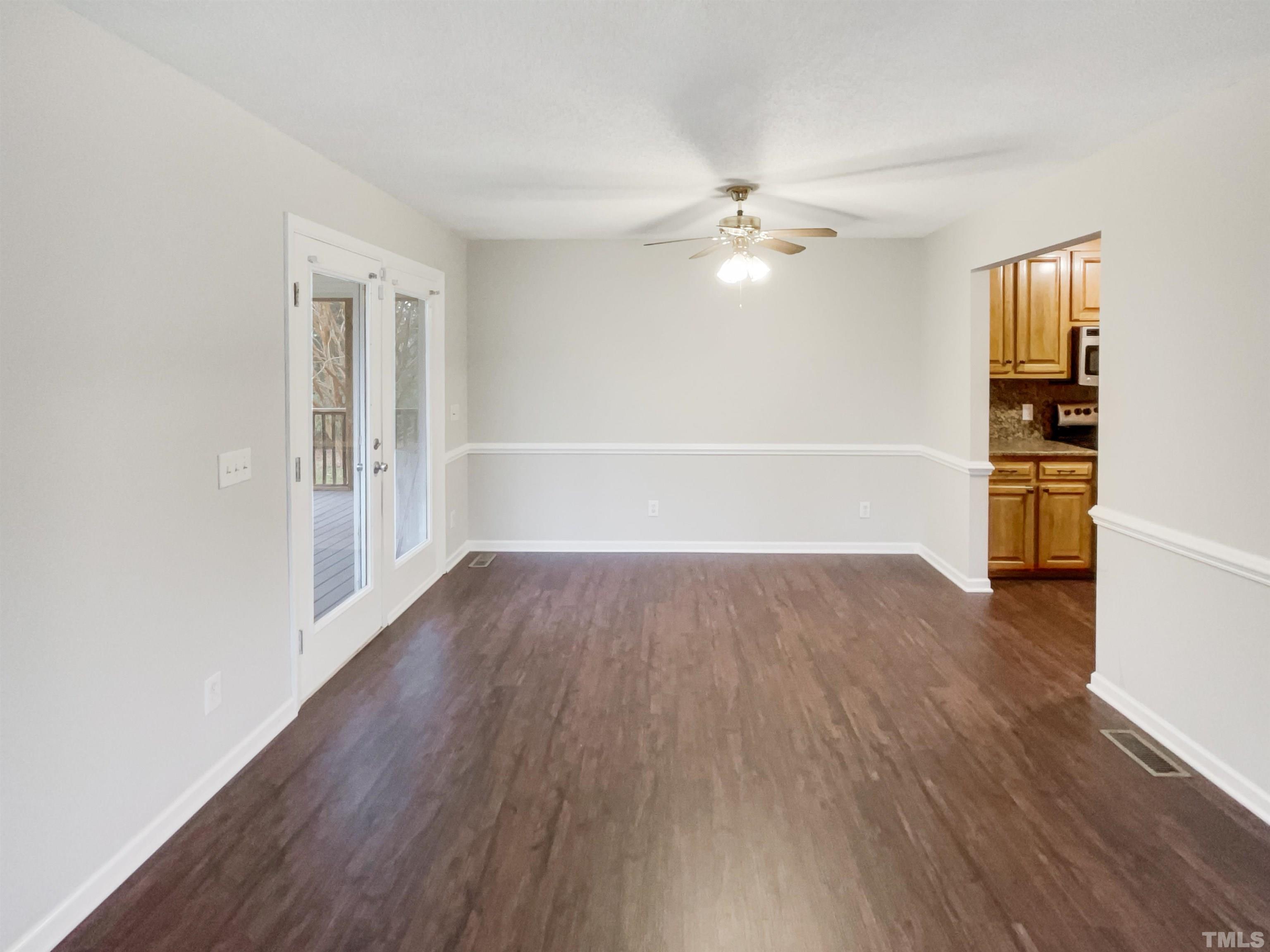 1459 Atkins Road Fuquay-Varina, NC 27526 - Photo 8 of 21 an empty room with wooden floor ceiling fan and windows