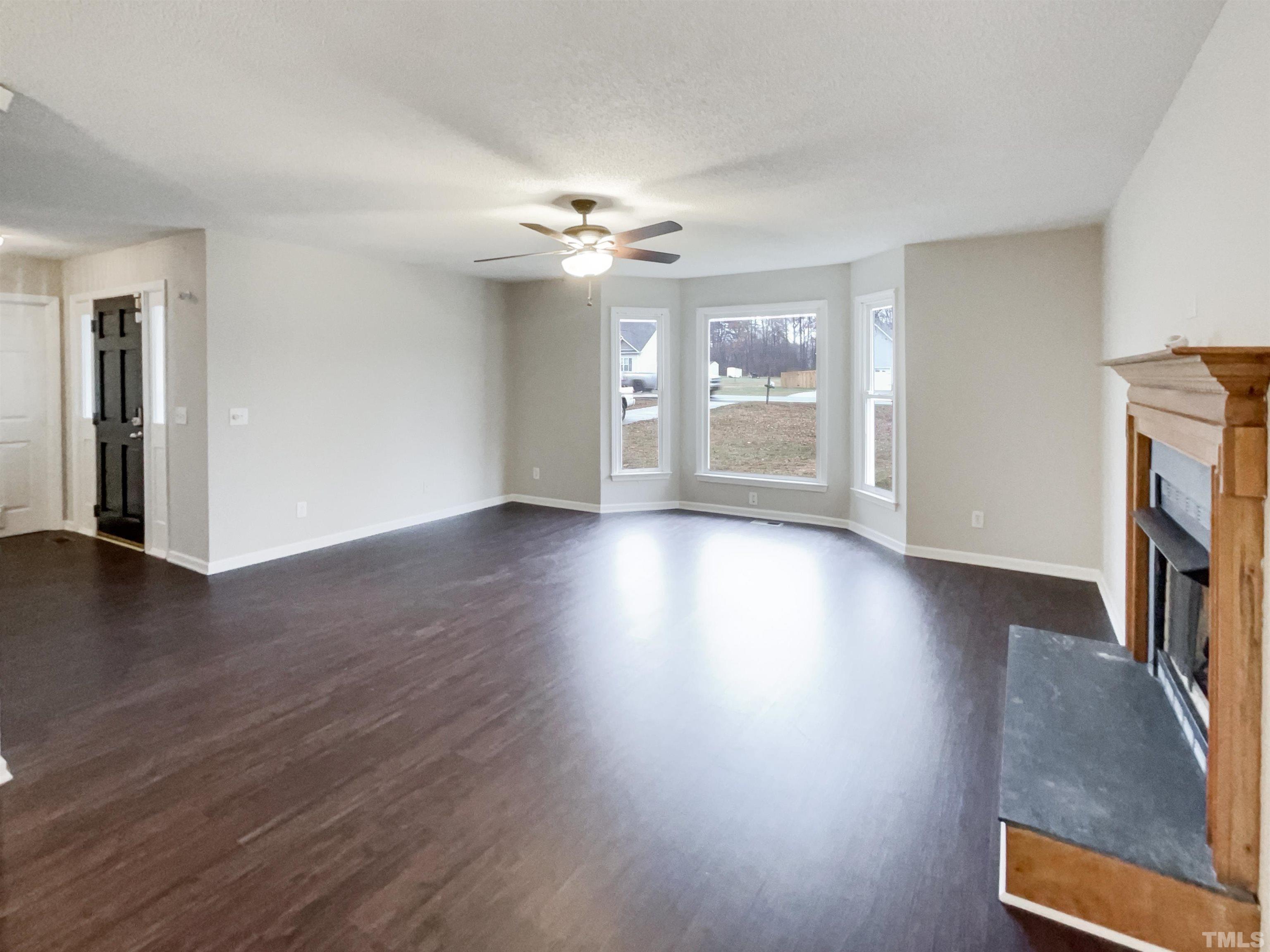 1459 Atkins Road Fuquay-Varina, NC 27526 - Photo 9 of 21 a view of a livingroom with wooden floor and a ceiling fan