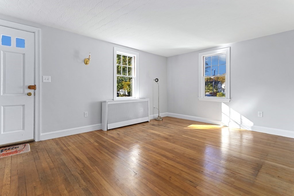 82 Spring Street Stoneham, MA 02180 - Photo 4 of 34 an empty room with wooden floor and windows