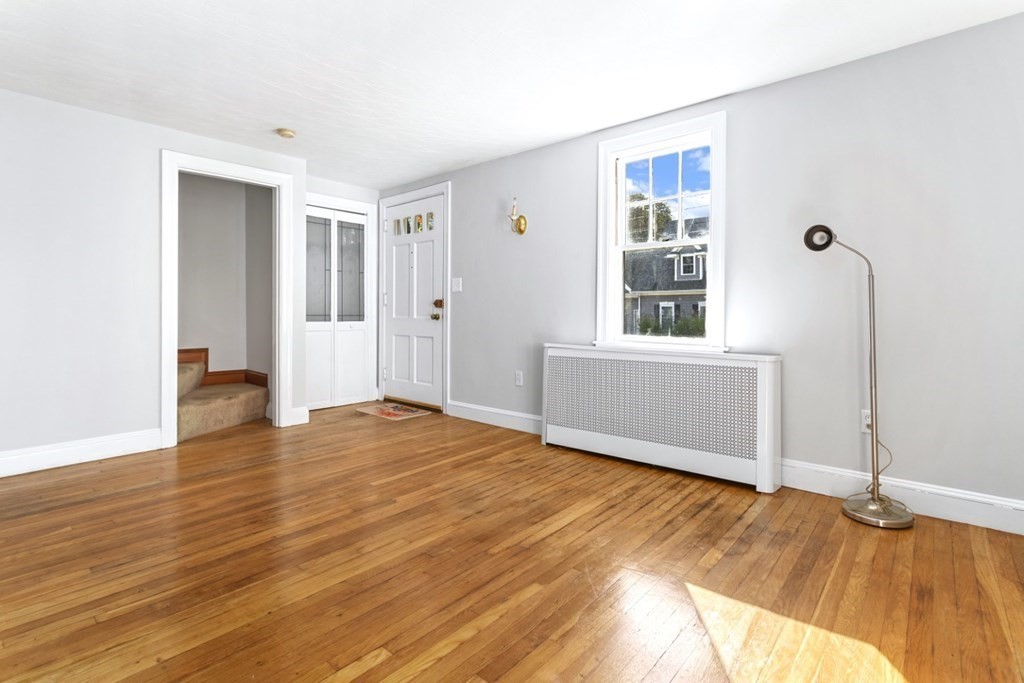 82 Spring Street Stoneham, MA 02180 - Photo 5 of 34 a view of an empty room with wooden floor and a window