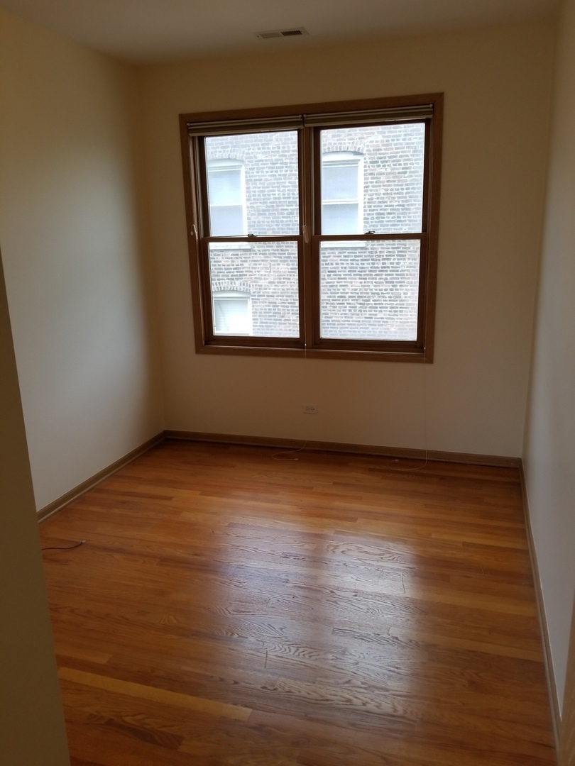 2226 West Monroe Street, Unit 3 Chicago, IL 60612 - Photo 16 of 17 an empty room with wooden floor and windows