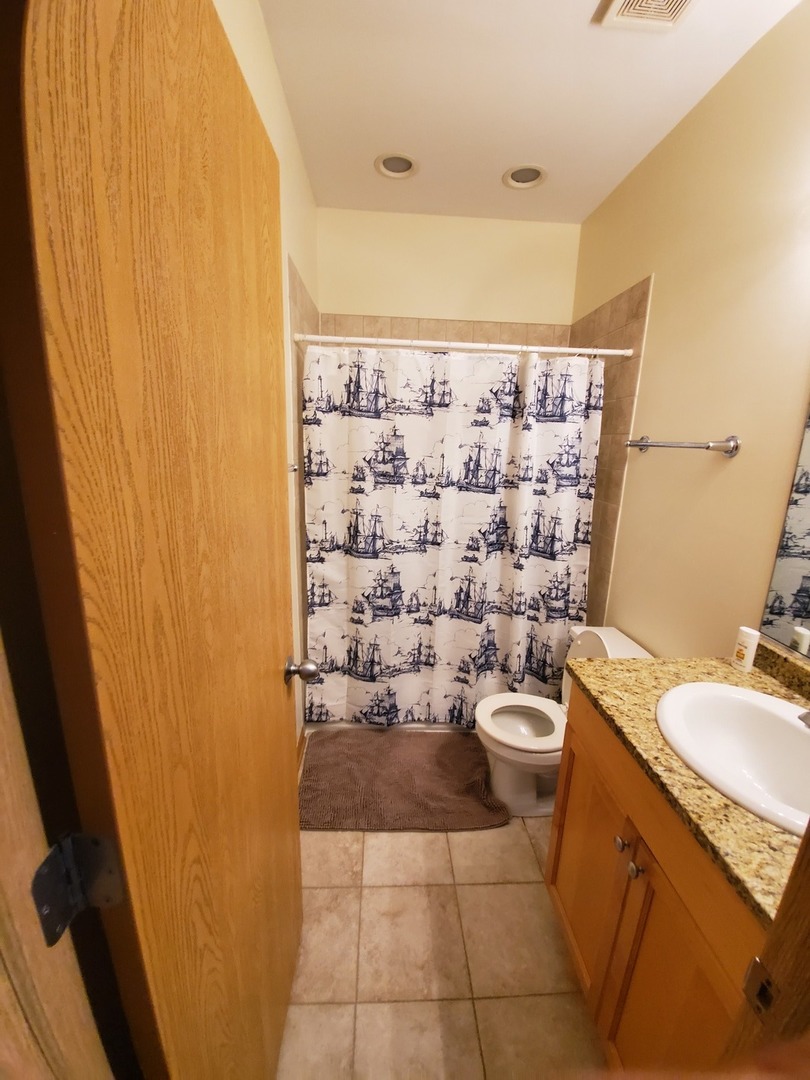 2226 West Monroe Street, Unit 3 Chicago, IL 60612 - Photo 10 of 17 a bathroom with a sink a toilet and shower curtain